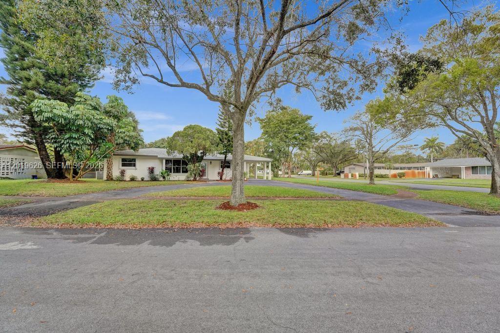 A single-story house with a circular driveway sits behind a large tree on a lawn — 101 SW 53rd Ave, Plantation FL 33317, PLANTATION, FL