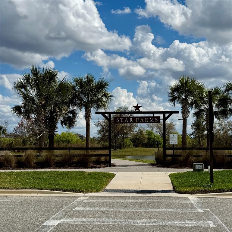 A wooden entrance sign labeled Star Farms stands over a paved path between palm trees — 3222 BITTERROOT LANE, BRADENTON, FL