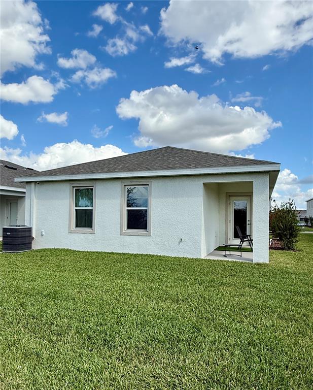 The exterior of a single-story house features a stucco finish, two windows, and a patio — 3222 BITTERROOT LANE, BRADENTON, FL