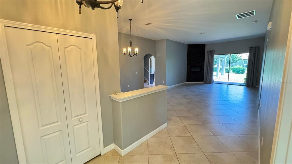 An interior view shows a tiled foyer with a closet, dining area, and living space — 1428 DEUCE CIRCLE, DAVENPORT, FL