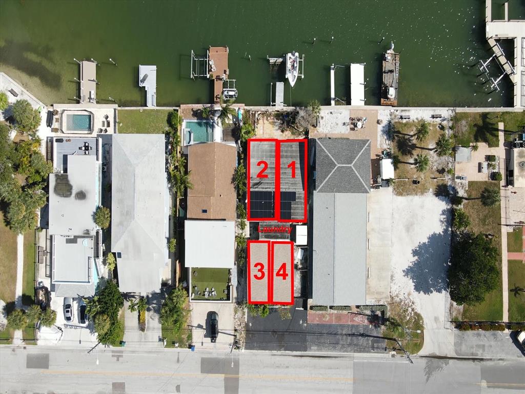 An aerial view shows four numbered sections of a waterfront property with boat docks — 7815 BOCA CIEGA DRIVE, ST PETE BEACH, FL