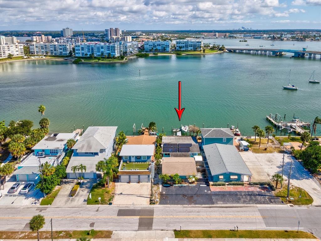 An aerial view shows a row of waterfront homes with docks along a bay — 7815 BOCA CIEGA DRIVE, ST PETE BEACH, FL