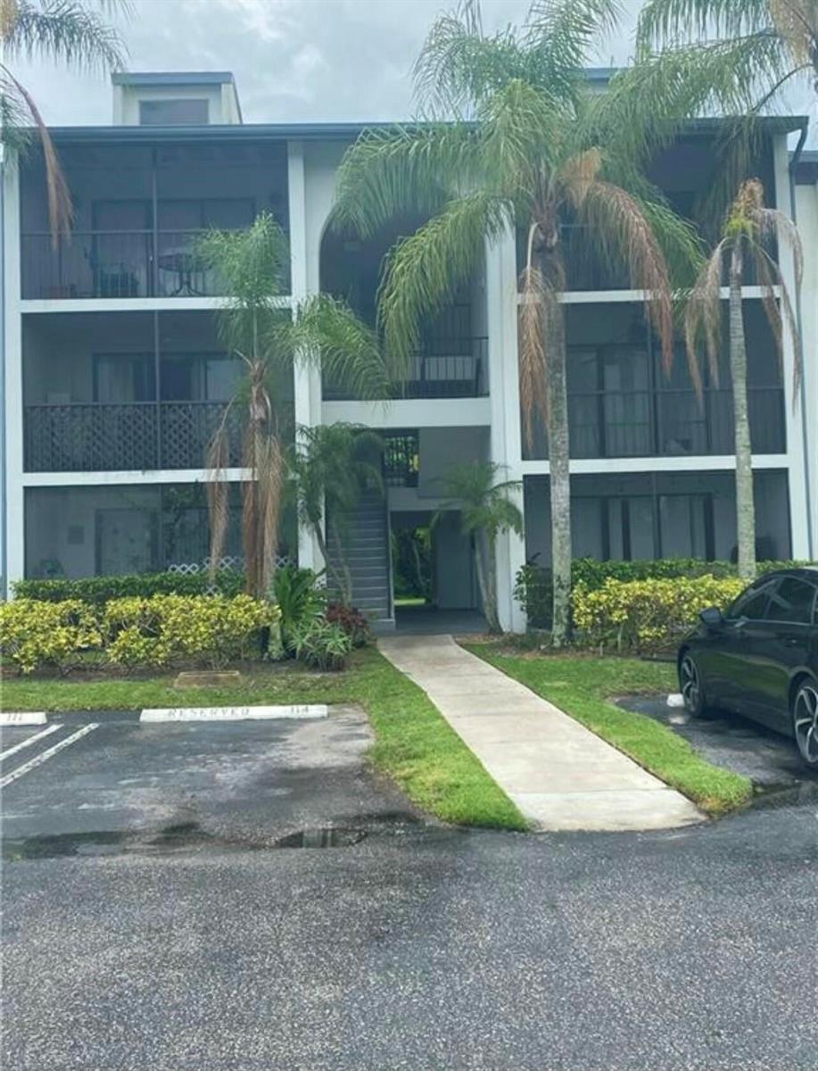 A three-story apartment building with screened balconies and palm trees in front — 1007 Green Pine Boulevard # D2, West Palm Beach FL 33409, WEST PALM BEACH, FL