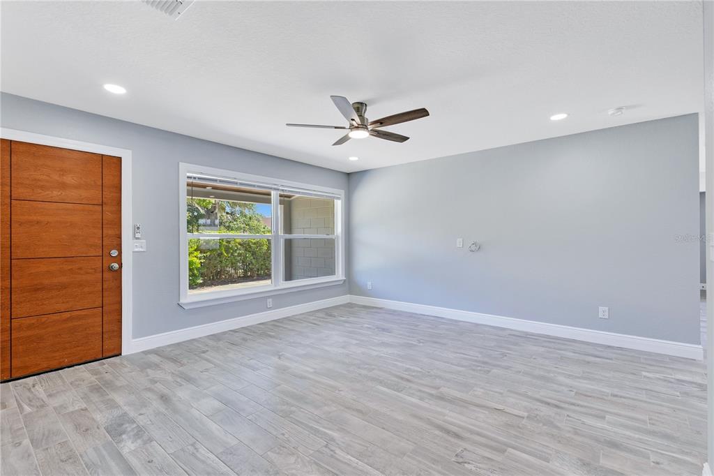 A detached garage with a white door sits behind a paved driveway and metal fence — 2419 ORANGE CENTER BOULEVARD, ORLANDO, FL