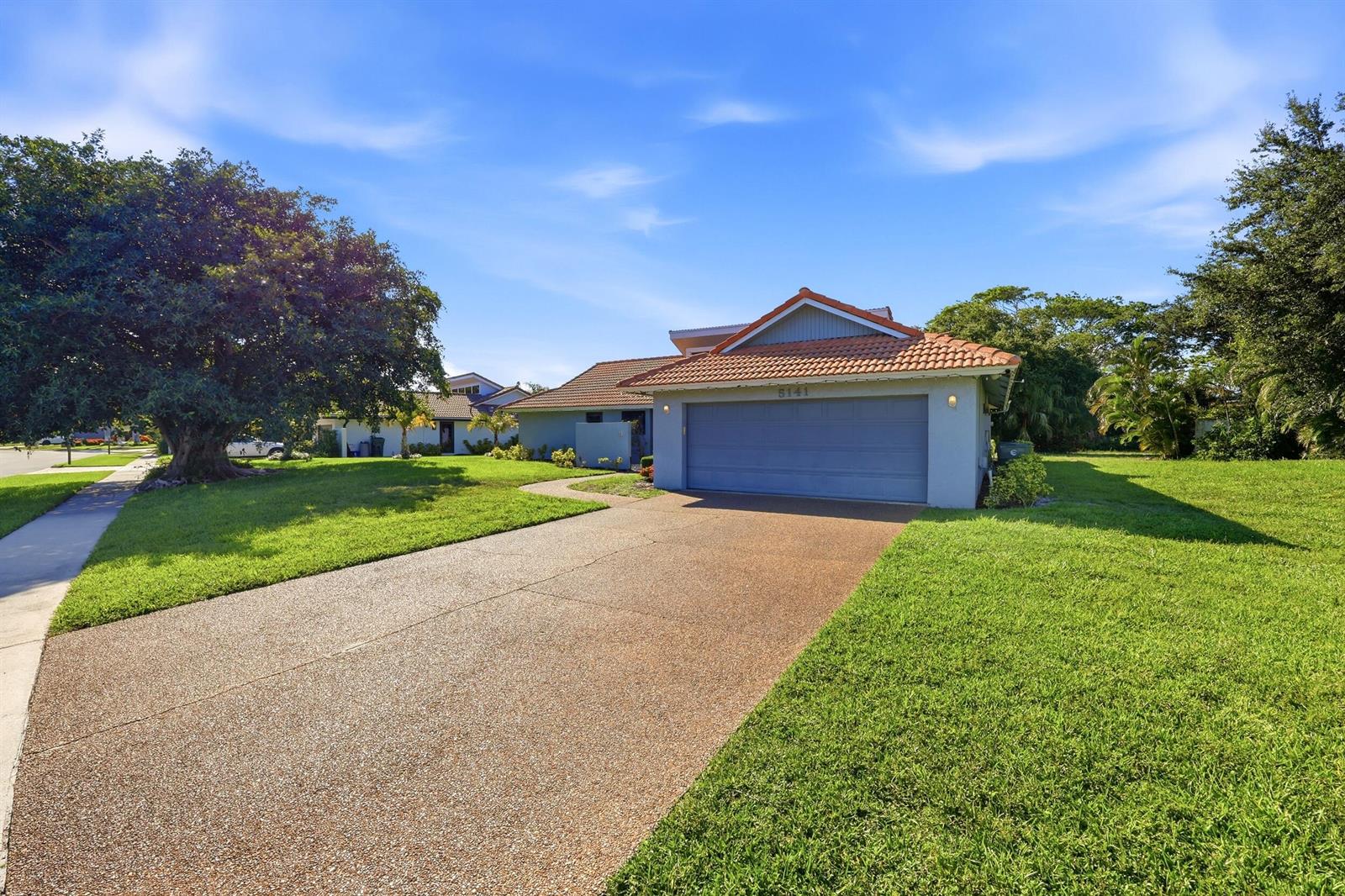 A single-story house with a two-car garage and a tiled roof sits on a lawn — 5141 NW 3rd Terrace, Boca Raton FL 33487, BOCA RATON, FL