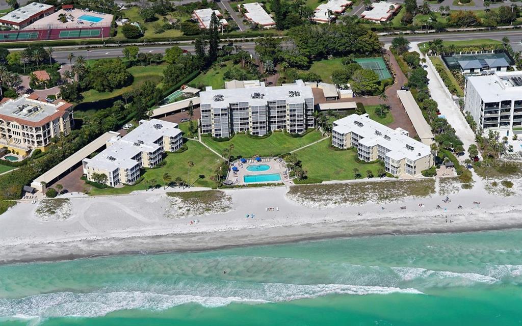 An aerial view of a beachfront condominium complex with a swimming pool and tennis courts — 4835 GULF OF MEXICO DRIVE UNIT 106, LONGBOAT KEY, FL
