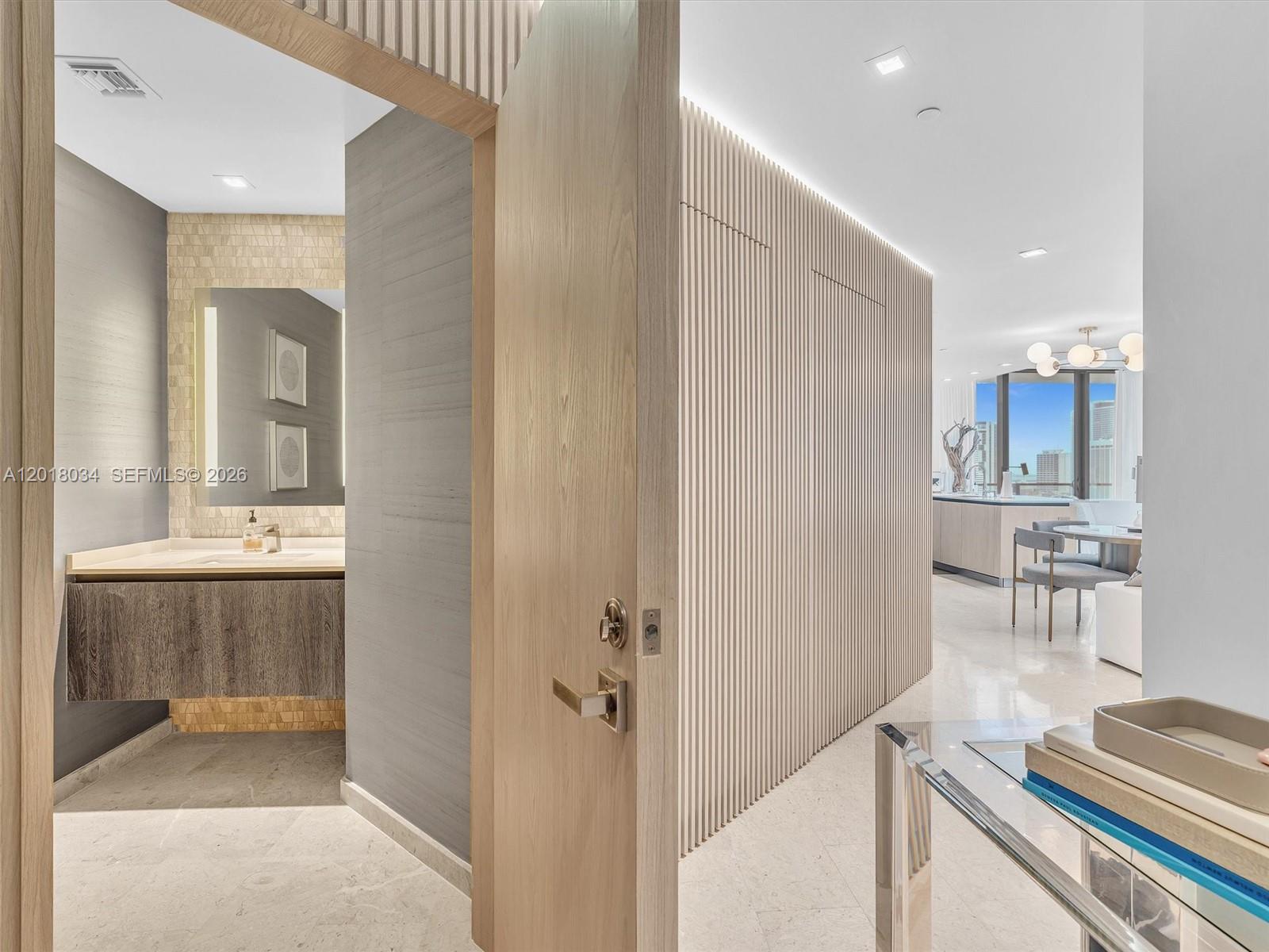 A view from a doorway shows a modern bathroom and a slatted wood wall — 88 SW 7th St, Miami FL 33130, MIAMI, FL