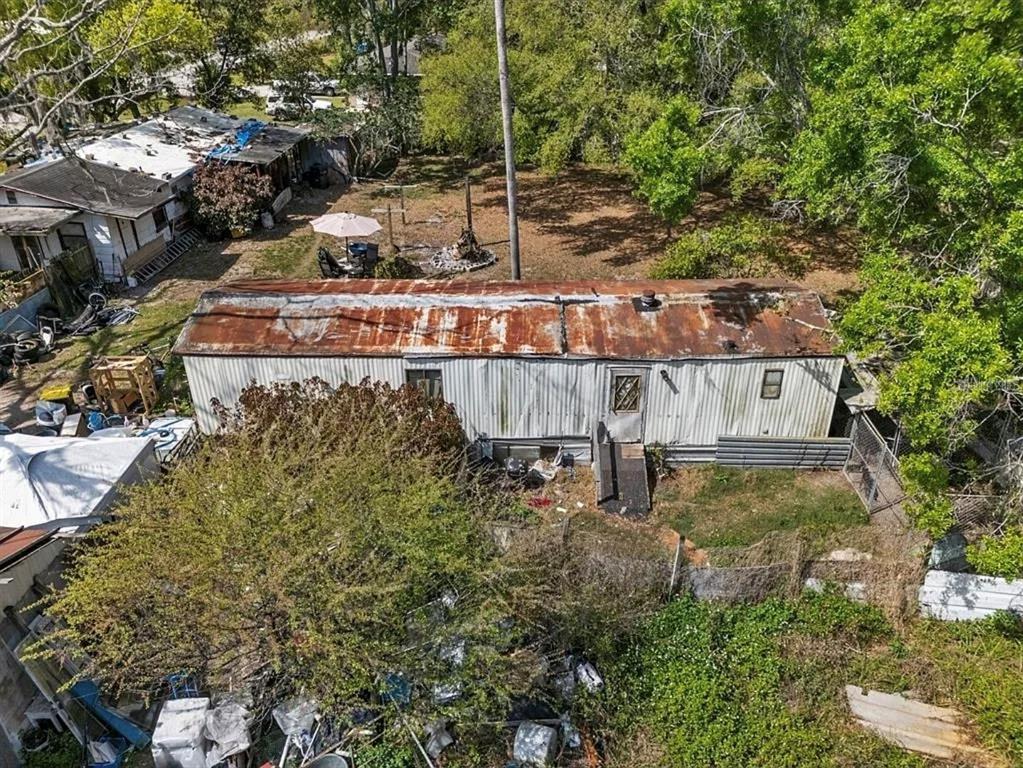 An aerial view shows a weathered mobile home with a rusted metal roof — 213 10TH WAHNETA STREET W, WINTER HAVEN, FL