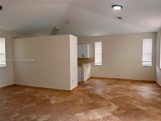 An open-concept room features light-colored walls, tiled flooring, and a partial kitchen wall — 21733 Ingraham Ave Rd # 21733, Cutler Bay FL 33190, CUTLER BAY, FL