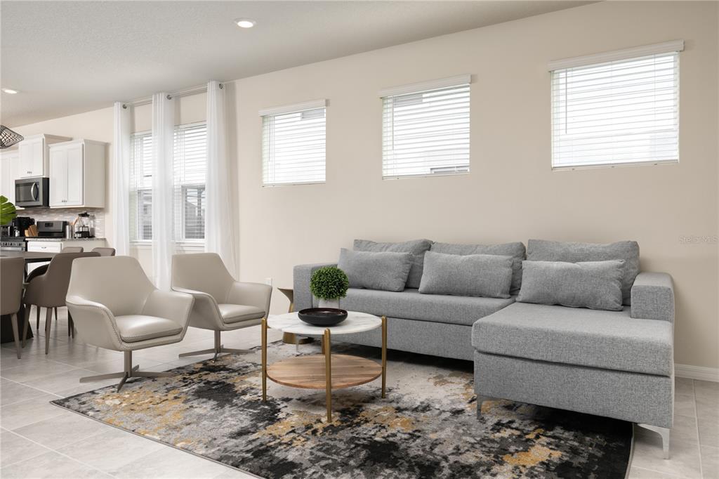 A living room features a gray sectional sofa, two armchairs, and a marble-topped coffee table — 7376 OAKMOSS LOOP, DAVENPORT, FL