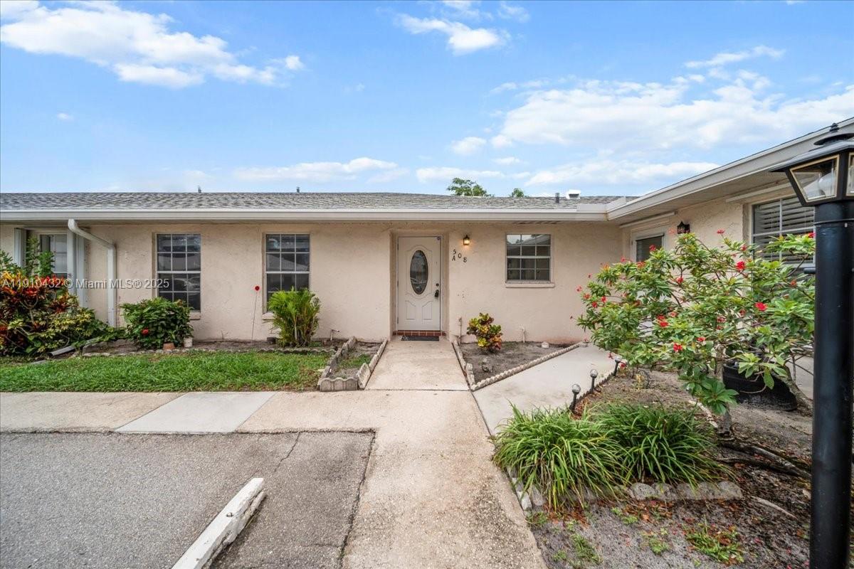 A single-story residential building exterior features a white front door and a concrete walkway — 508 Holyoke Ln # A, Lake Worth FL 33467, LAKE WORTH, FL
