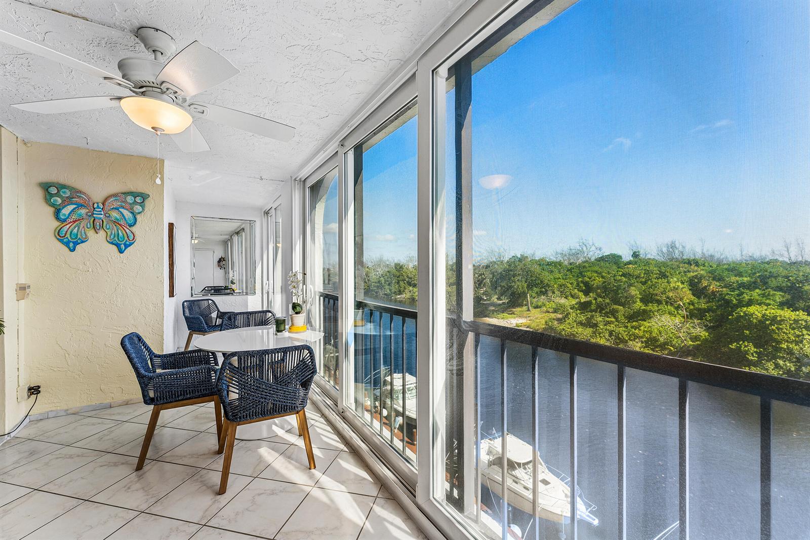 A sunroom with tile flooring, a ceiling fan, and a balcony overlooking a waterway — 1631 Riverview Road # 505, Deerfield Beach FL 33441, DEERFIELD BEACH, FL