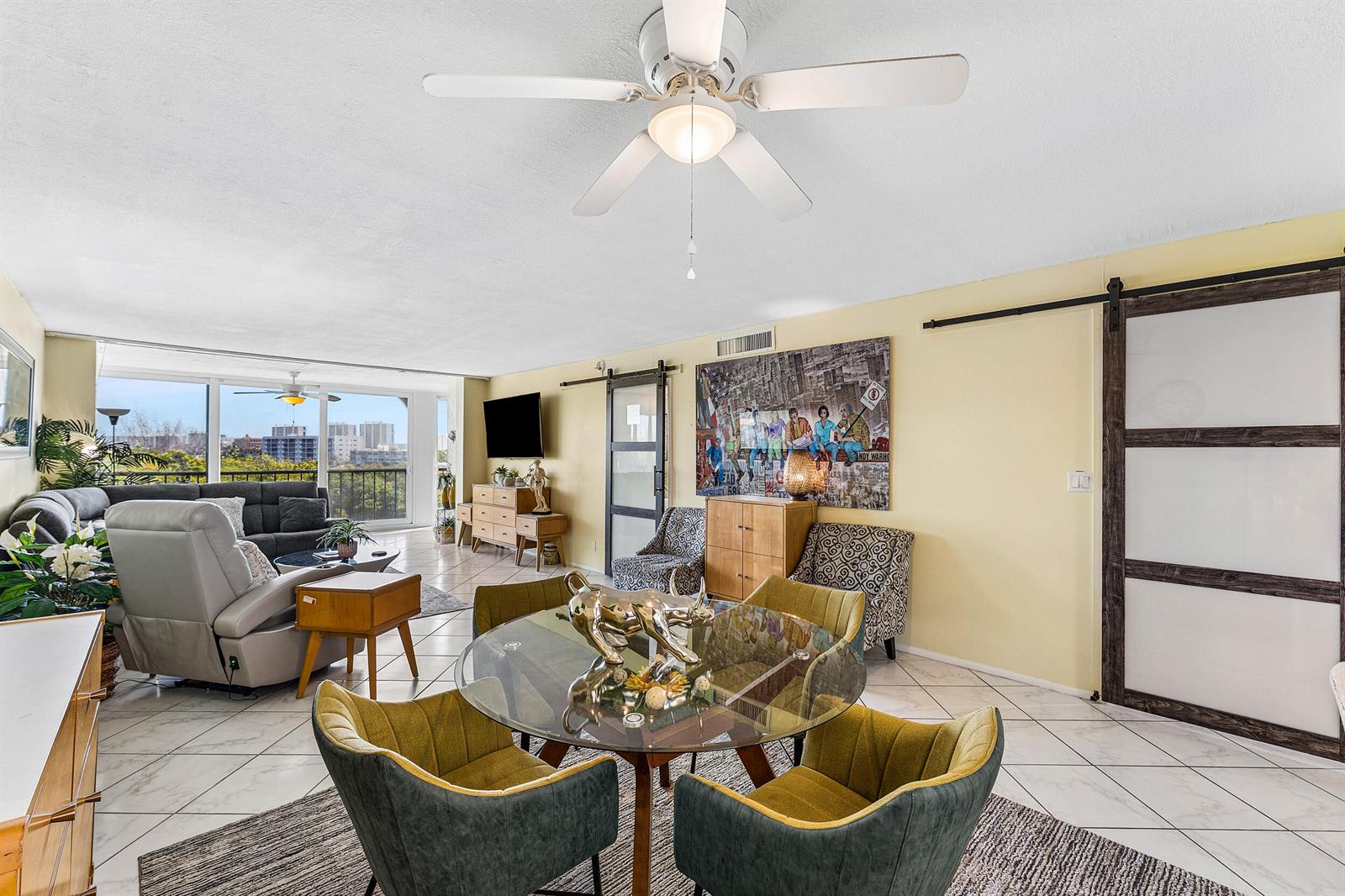 A living and dining area features tile floors, a glass table, and a sliding barn door — 1631 Riverview Road # 505, Deerfield Beach FL 33441, DEERFIELD BEACH, FL
