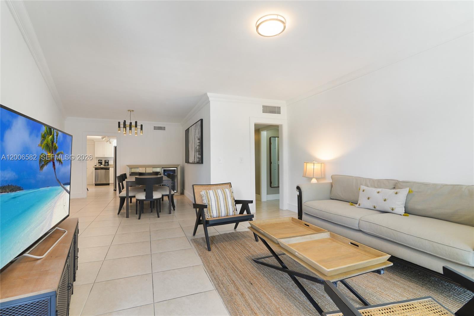 A living room and dining area feature tile floors, a neutral sofa, and modern furniture — 1142 99th St # 24, Bay Harbor Islands FL 33154, BAY HARBOR ISLANDS, FL