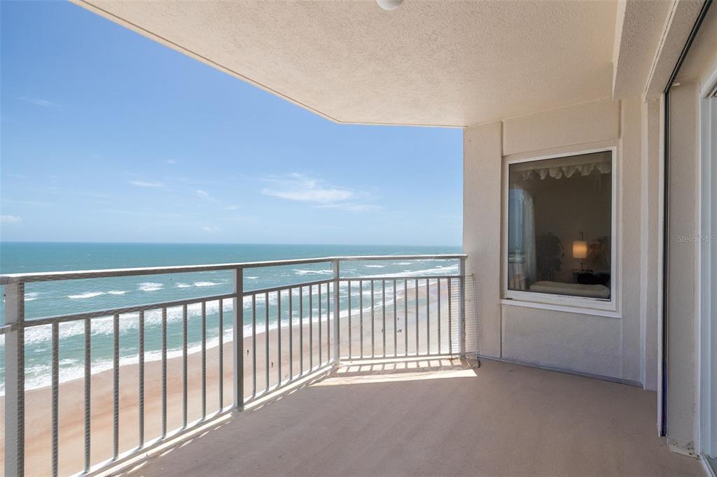 A balcony with a metal railing overlooks the ocean and a sandy beach — 2967 S ATLANTIC AVENUE UNIT 1204, DAYTONA BEACH SHORES, FL