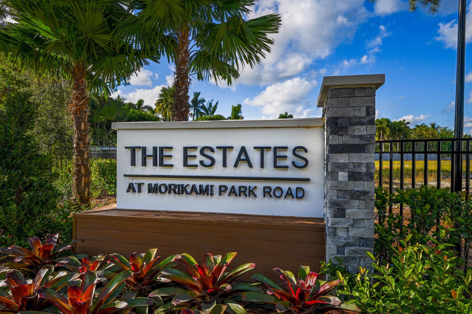A sign for The Estates at Morikami Park Road stands in front of tropical landscaping — 16670 Mosaic Place, Delray Beach FL 33446, DELRAY BEACH, FL