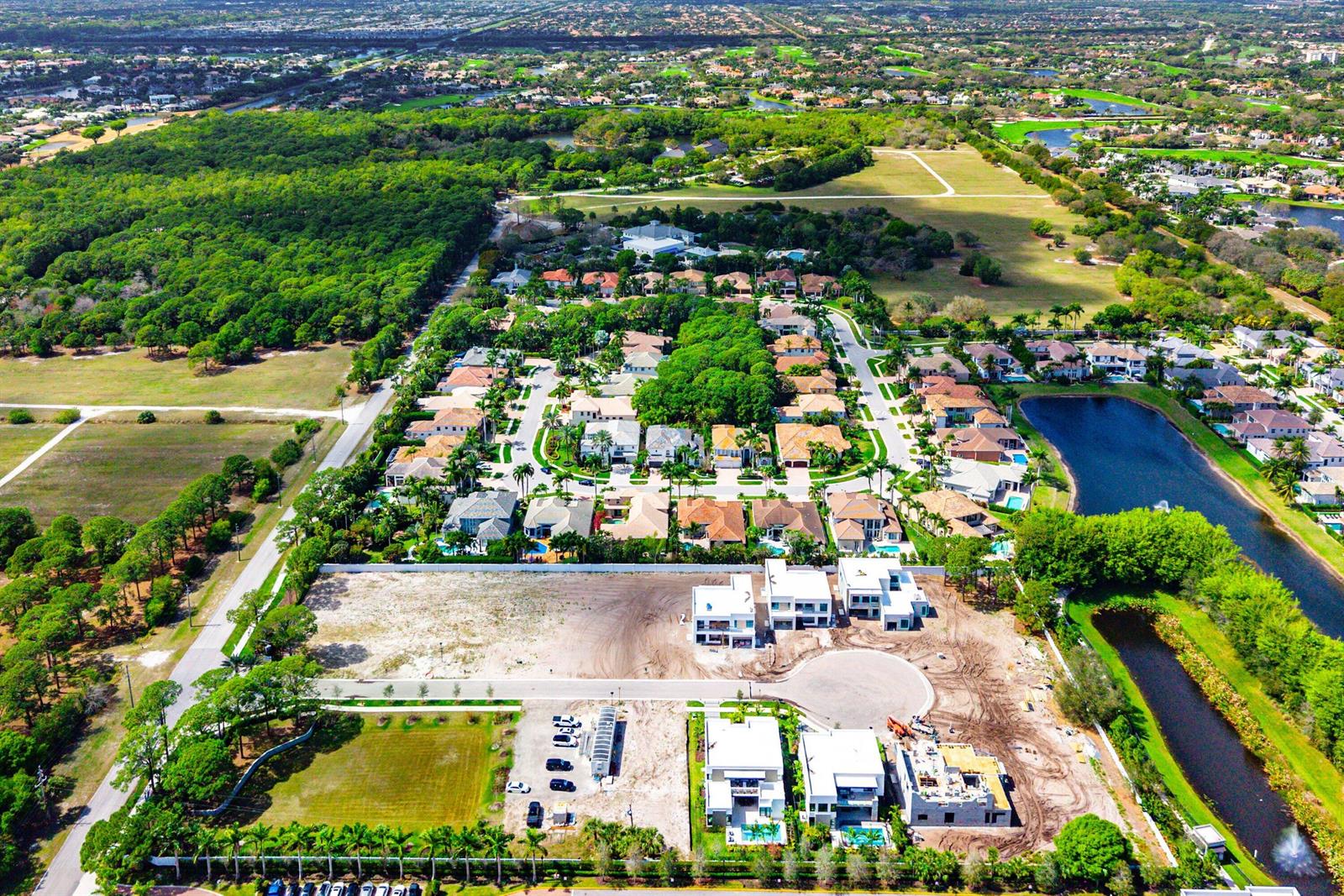 An aerial view shows a suburban neighborhood with established homes and new construction under development — 16670 Mosaic Place, Delray Beach FL 33446, DELRAY BEACH, FL