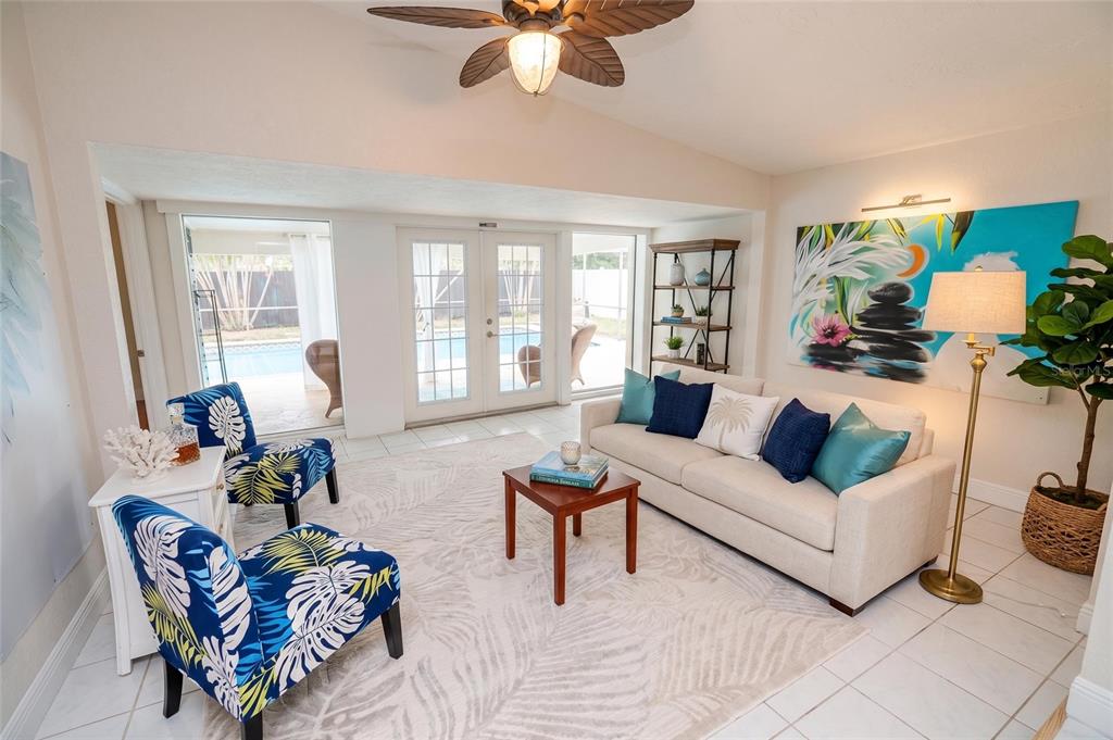 A living room with a sofa, two patterned armchairs, a coffee table, and pool views — 3641 STOKES DRIVE, SARASOTA, FL