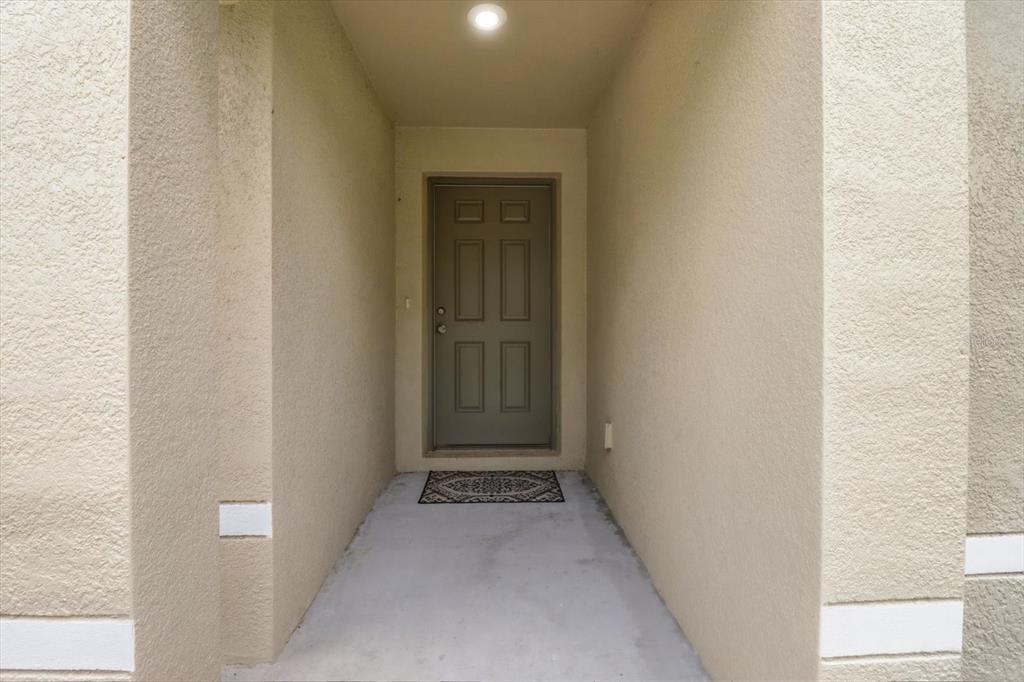 A single-story house with a tan exterior and attached garage sits next to a wooded lot — 8827 N VIENNA DRIVE, DUNNELLON, FL