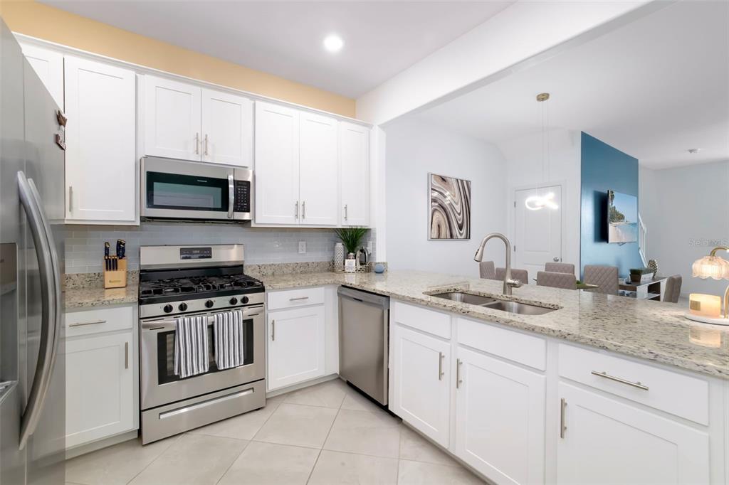 A kitchen with white cabinets, stainless steel appliances, and granite countertops — 15030 SUNNY DAY DRIVE, BRADENTON, FL