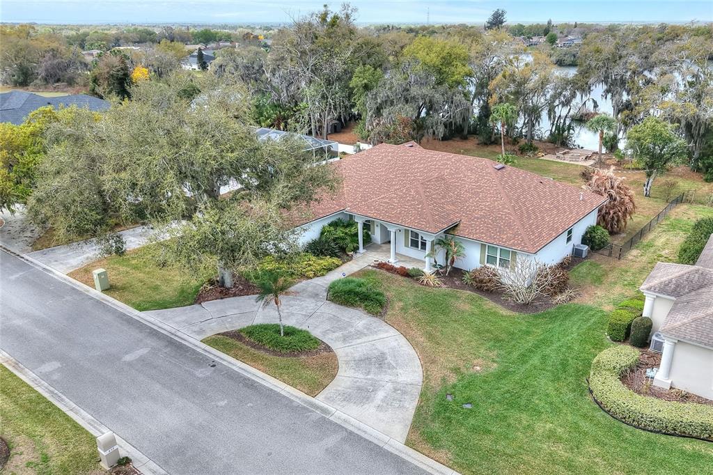 An aerial view shows a single-story house with a brown roof and a circular driveway — 858 HANOVER WAY, LAKELAND, FL