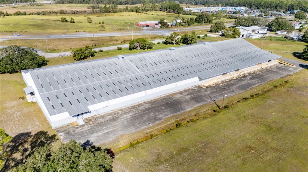 An aerial view shows a large industrial warehouse building surrounded by open fields and roads — 14281 US HWY 301, STARKE, FL