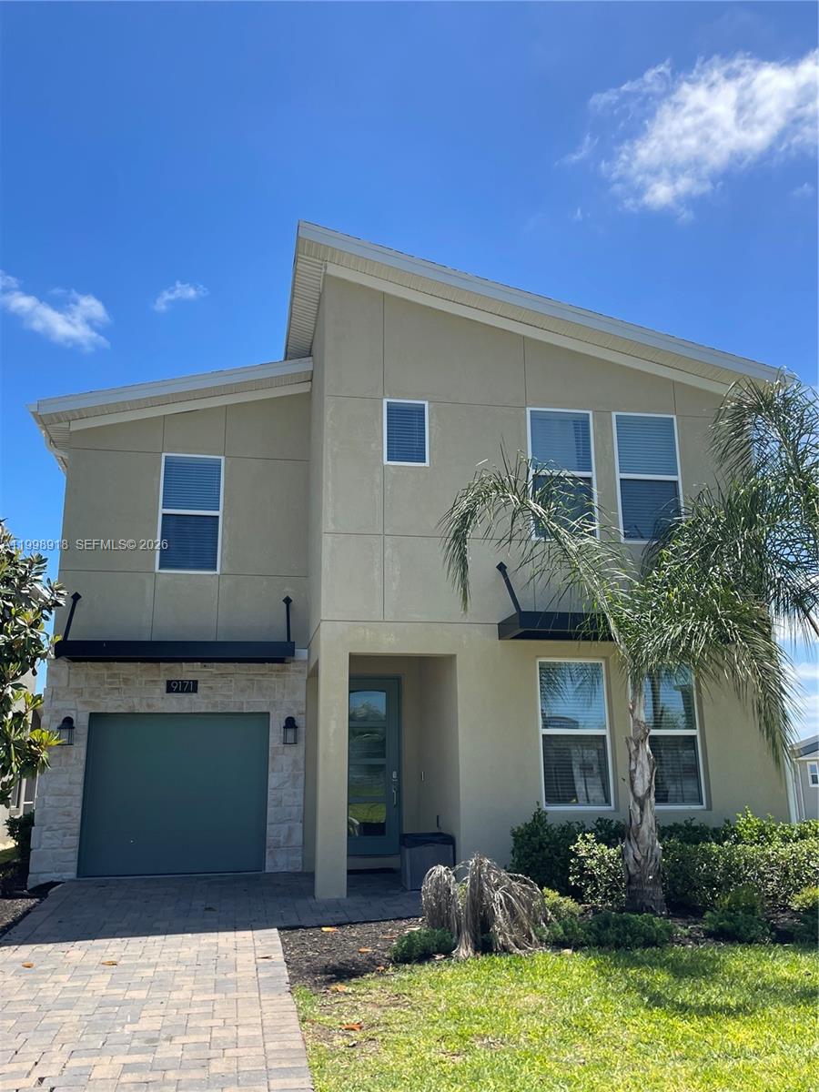 A two-story house features a tan stucco exterior, a stone-accented garage, and a palm tree — OTHER CITY - IN THE STATE OF FLORIDA, FL