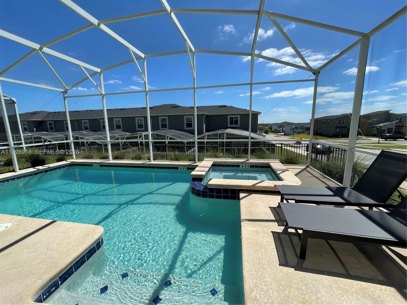 A screened-in swimming pool and hot tub are situated on a patio with lounge chairs — OTHER CITY - IN THE STATE OF FLORIDA, FL