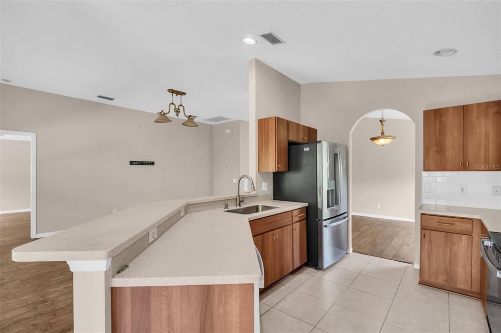 A kitchen with wood cabinets, a breakfast bar, and stainless steel appliances — 12415 RUSTIC VIEW COURT, TAMPA, FL
