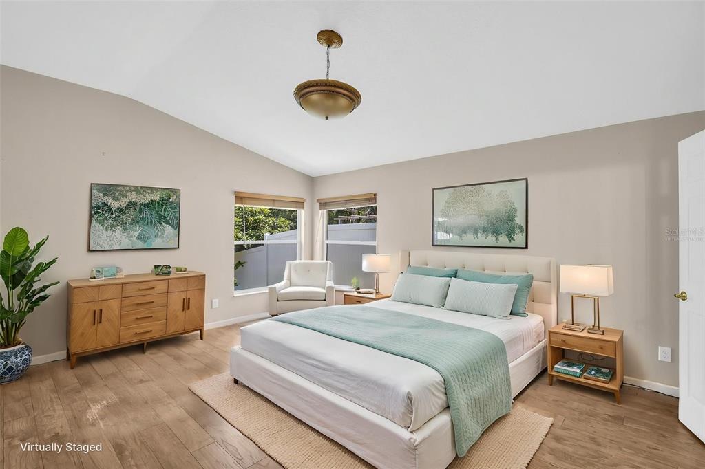 A bedroom features a bed, wooden dresser, two windows, and a light fixture — 12415 RUSTIC VIEW COURT, TAMPA, FL