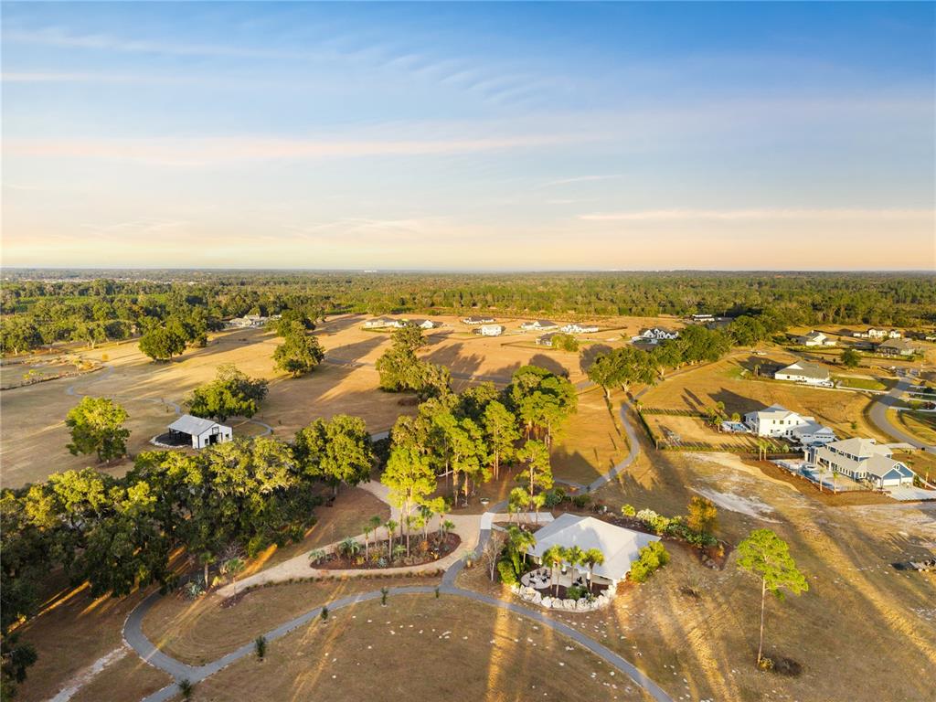 An aerial view shows a rural property with a house, a barn, and walking paths — Lot 39 SW 124TH WAY, ARCHER, FL