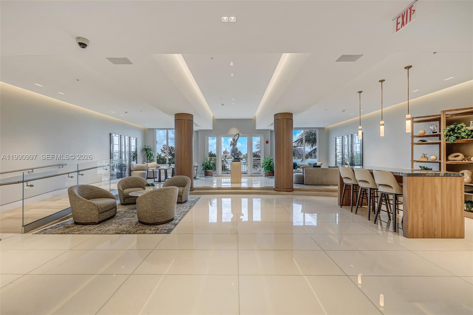 A modern, open-concept lobby features polished tile floors, two large columns, and a bar area — 888 Brickell Key Dr # 807, Miami FL 33131, MIAMI, FL
