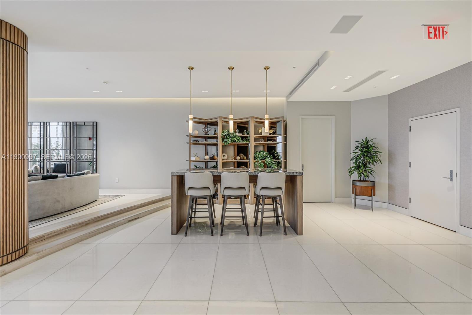A modern room features a kitchen island with three stools, shelving, and white tile flooring — 888 Brickell Key Dr # 807, Miami FL 33131, MIAMI, FL