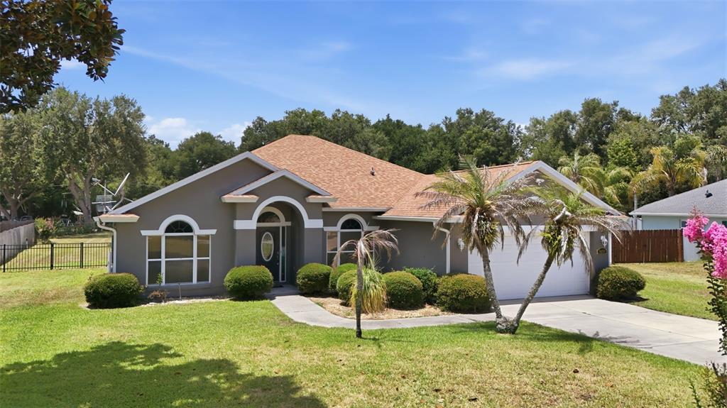 A single-story house with a brown exterior, a shingled roof, and a front-facing garage — 36723 SUNDANCE DRIVE, GRAND ISLAND, FL