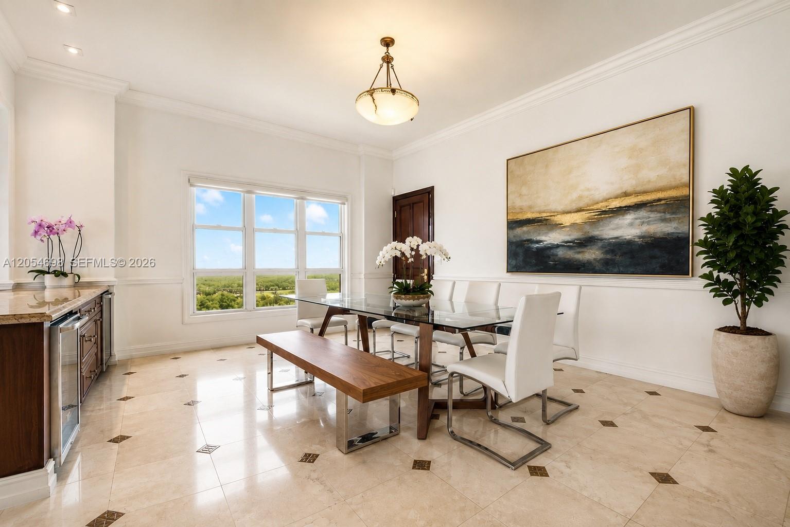 A dining room features a glass table, white chairs, a wooden bench, and tile flooring — 13633 Deering Bay Dr, Coral Gables FL 33158, CORAL GABLES, FL
