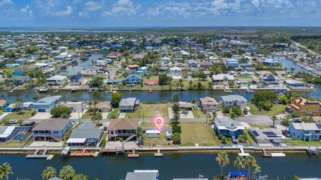 An aerial view shows a waterfront residential lot with a small structure and boat docks — 4274 CARLOS COURT, HERNANDO BEACH, FL