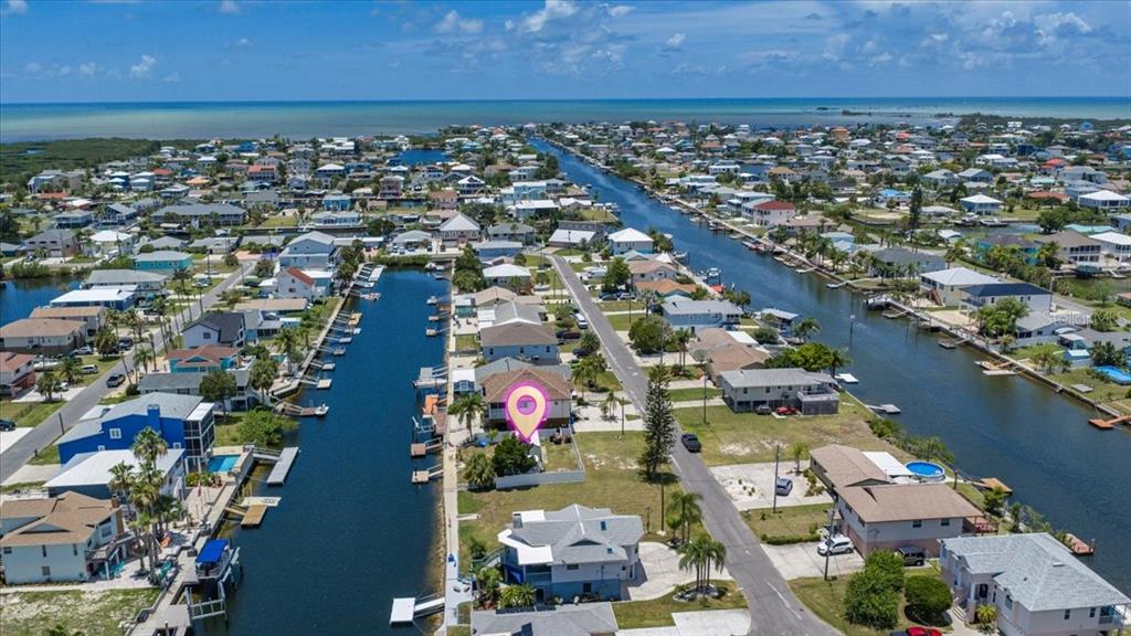 An aerial view shows a waterfront house with a pink location pin in a neighborhood — 4274 CARLOS COURT, HERNANDO BEACH, FL