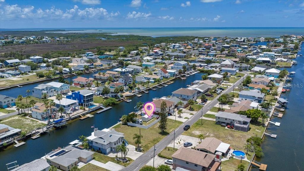 An aerial view shows a waterfront house with a pin marker in a residential neighborhood — 4274 CARLOS COURT, HERNANDO BEACH, FL