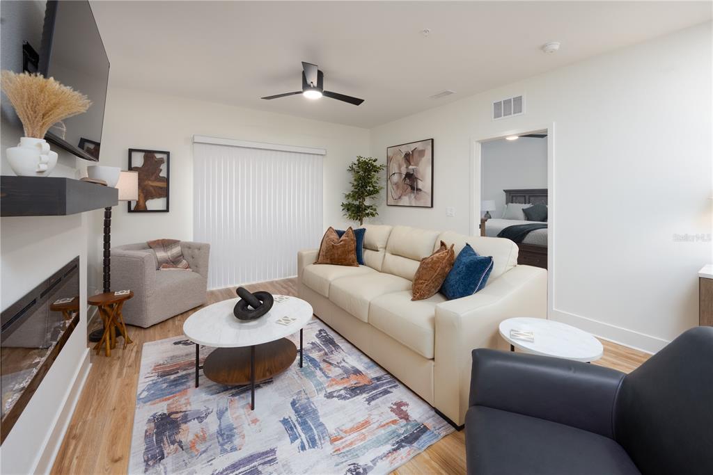 A living room features a fireplace, a white sofa, a coffee table, and a ceiling fan — 419 SE 1ST AVENUE UNIT 101, OCALA, FL