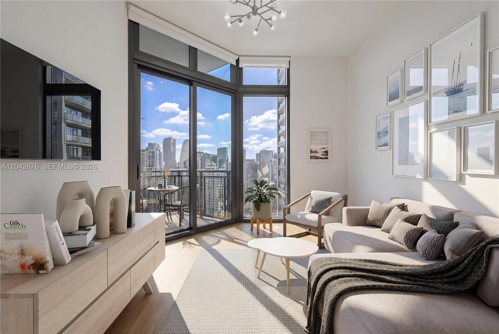 A modern living room features a sectional sofa, floor-to-ceiling windows, and a city skyline view — 650 NE 2nd Ave # 3504, Miami FL 33132, MIAMI, FL