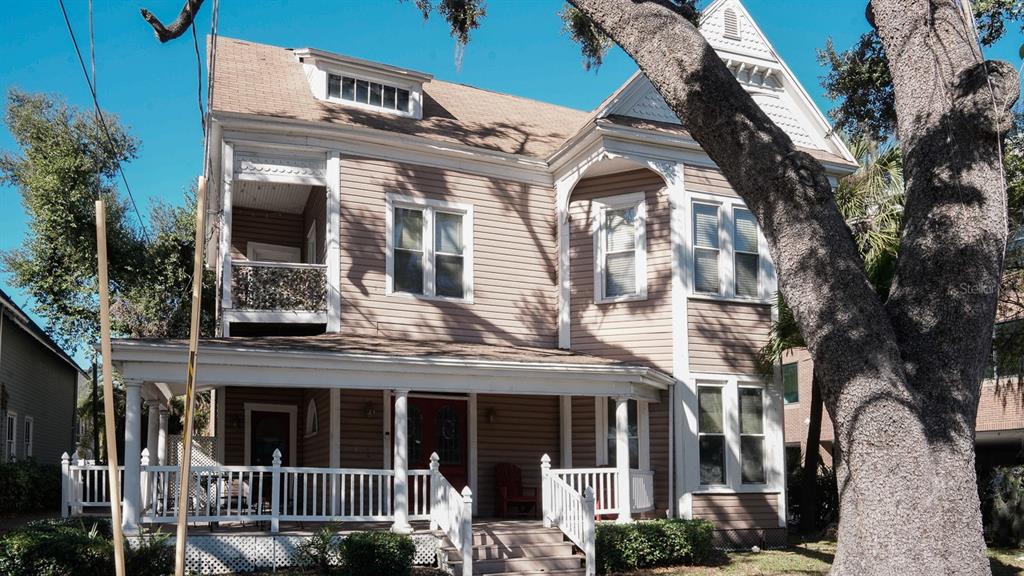A two-story tan house with a front porch, a balcony, and a large tree — 333 S PLANT AVENUE, TAMPA, FL