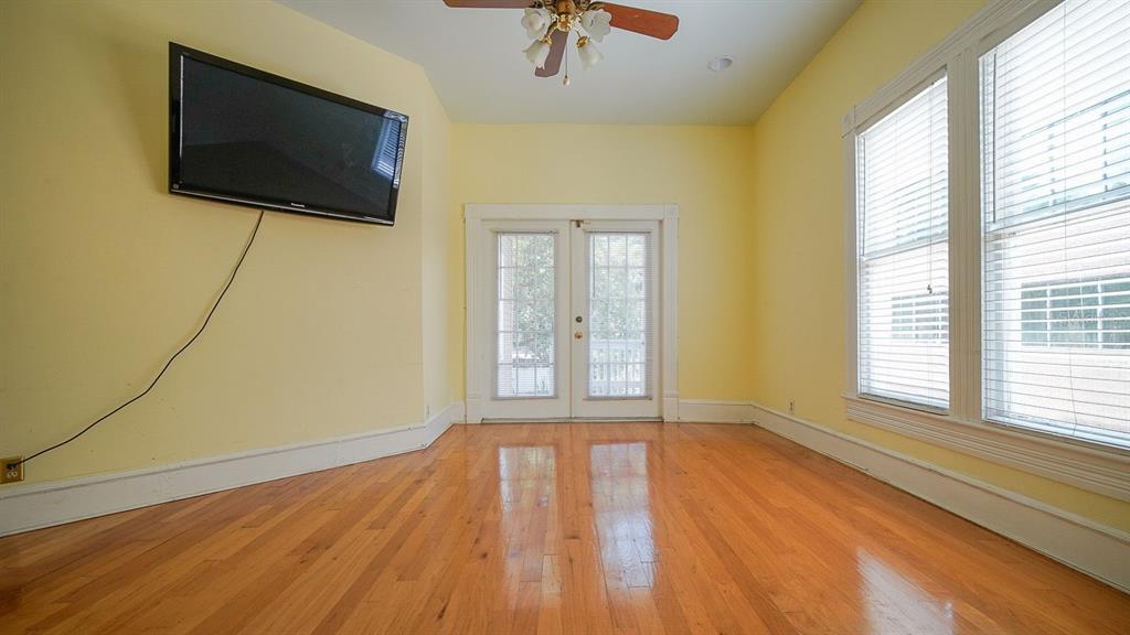 An empty room with yellow walls, hardwood floors, a ceiling fan, and French doors — 333 S PLANT AVENUE, TAMPA, FL