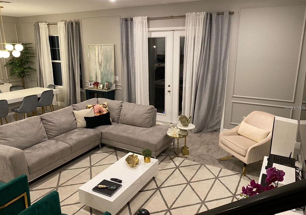 A living room features a grey sectional sofa, a white coffee table, and an accent chair — 14739 GLADE HILL PARK WAY, WINTER GARDEN, FL