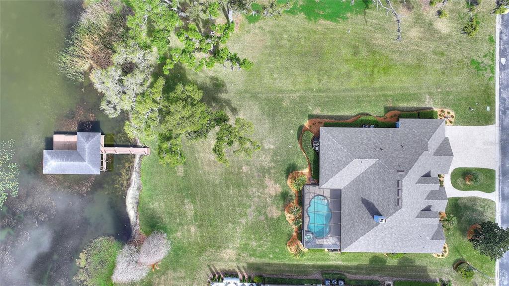 An aerial view shows a house with a pool, a dock, and a large grassy yard — 4848 ISLAND SHORES LANE, LAKELAND, FL