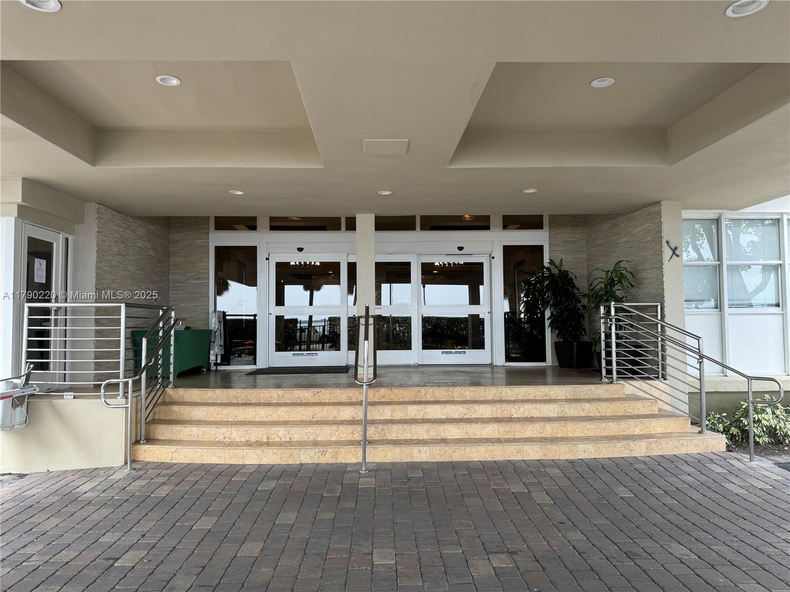The exterior entrance features a set of stone steps leading to glass double doors — 1420 Brickell Bay Dr, Miami FL 33131, MIAMI, FL