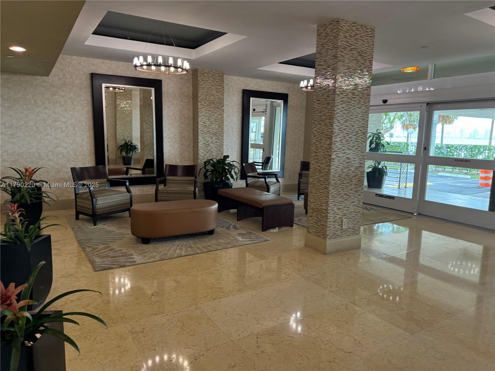 A lobby features tiled floors, seating areas with mirrors, and glass doors leading outside — 1420 Brickell Bay Dr, Miami FL 33131, MIAMI, FL