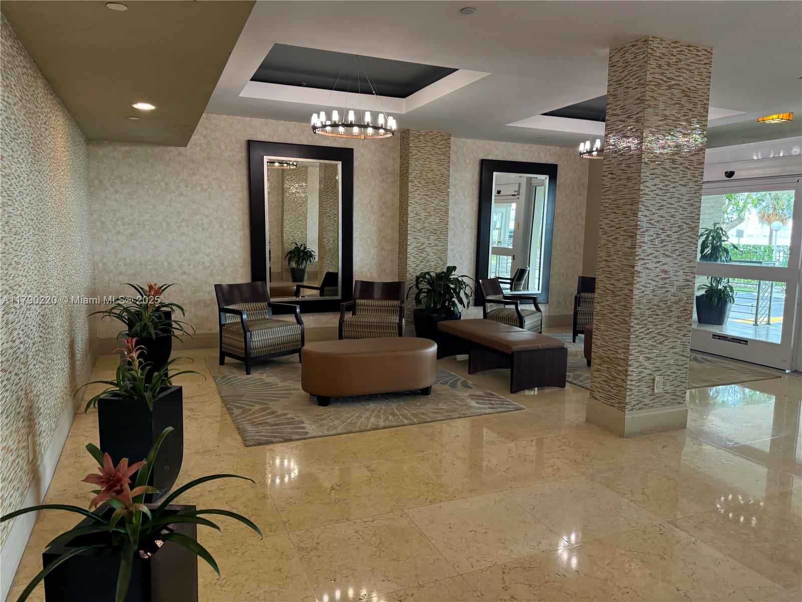 A lobby features tiled floors, two mirrors, seating areas, and decorative columns with mosaic tiles — 1420 Brickell Bay Dr, Miami FL 33131, MIAMI, FL