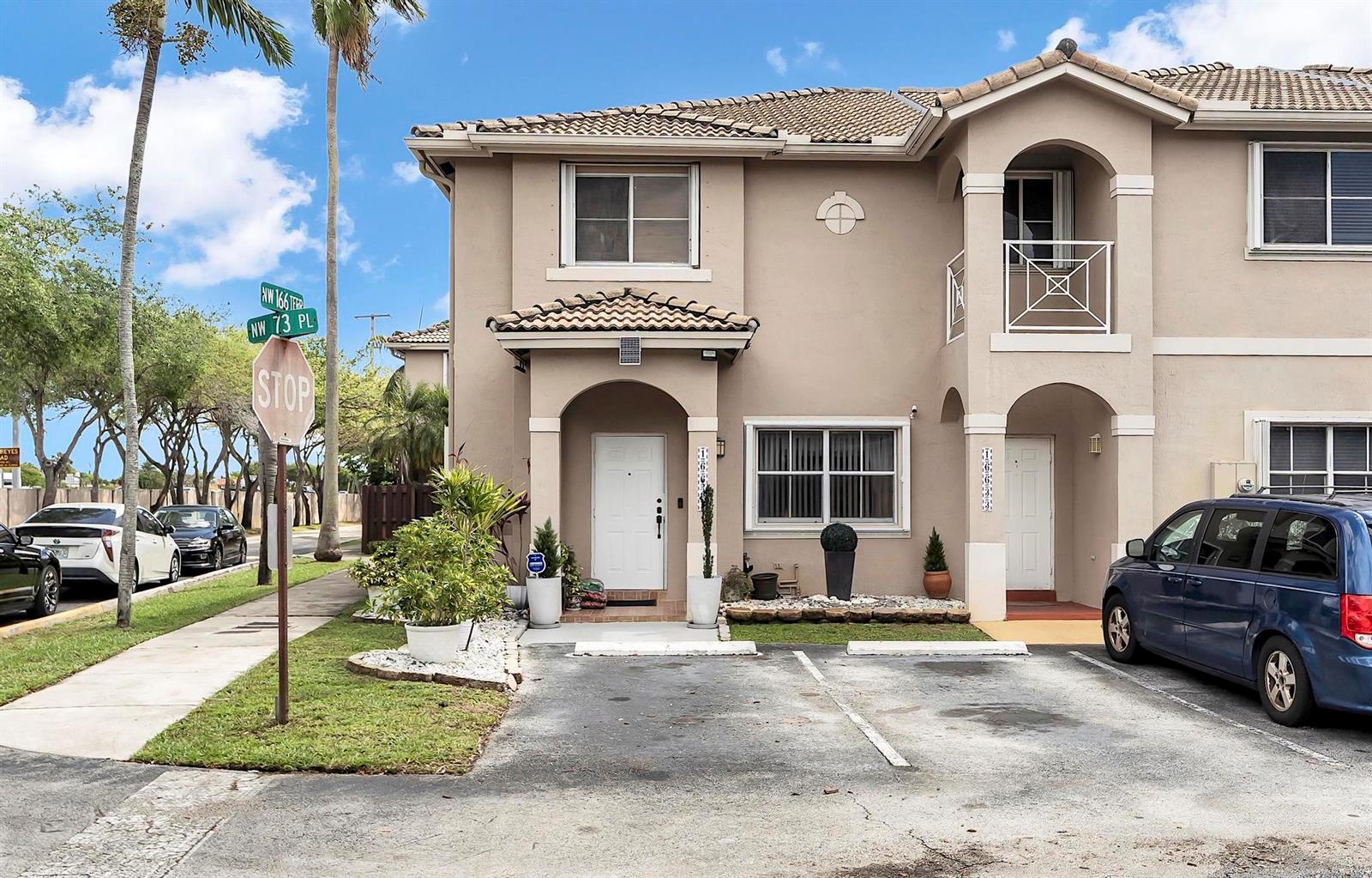 A two-story tan townhouse with a tiled roof, two front doors, and a parking area — 16637 NW 73rd Place, Miami Lakes FL 33014, MIAMI LAKES, FL