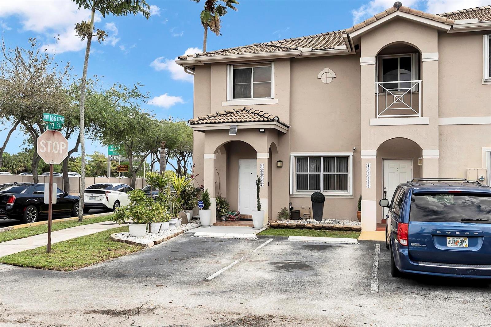 A two-story tan townhouse with a paved parking area and a stop sign nearby — 16637 NW 73rd Place, Miami Lakes FL 33014, MIAMI LAKES, FL