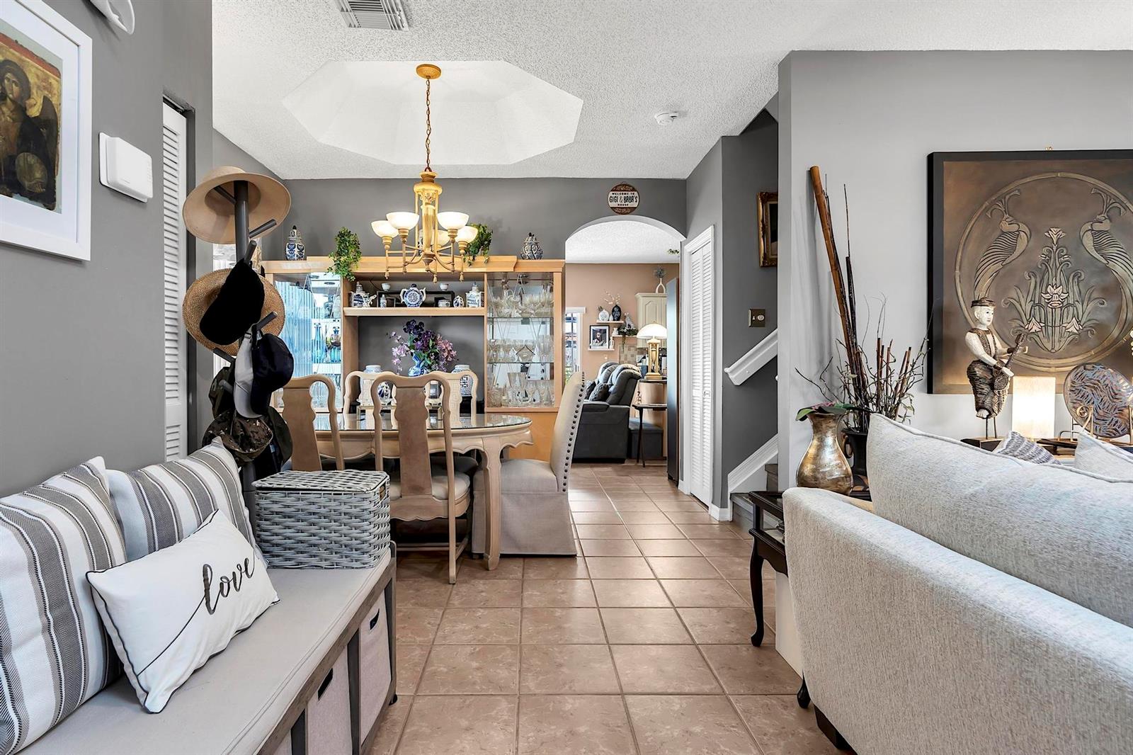 A dining area with a hutch and chandelier sits between a living room and entryway — 16637 NW 73rd Place, Miami Lakes FL 33014, MIAMI LAKES, FL